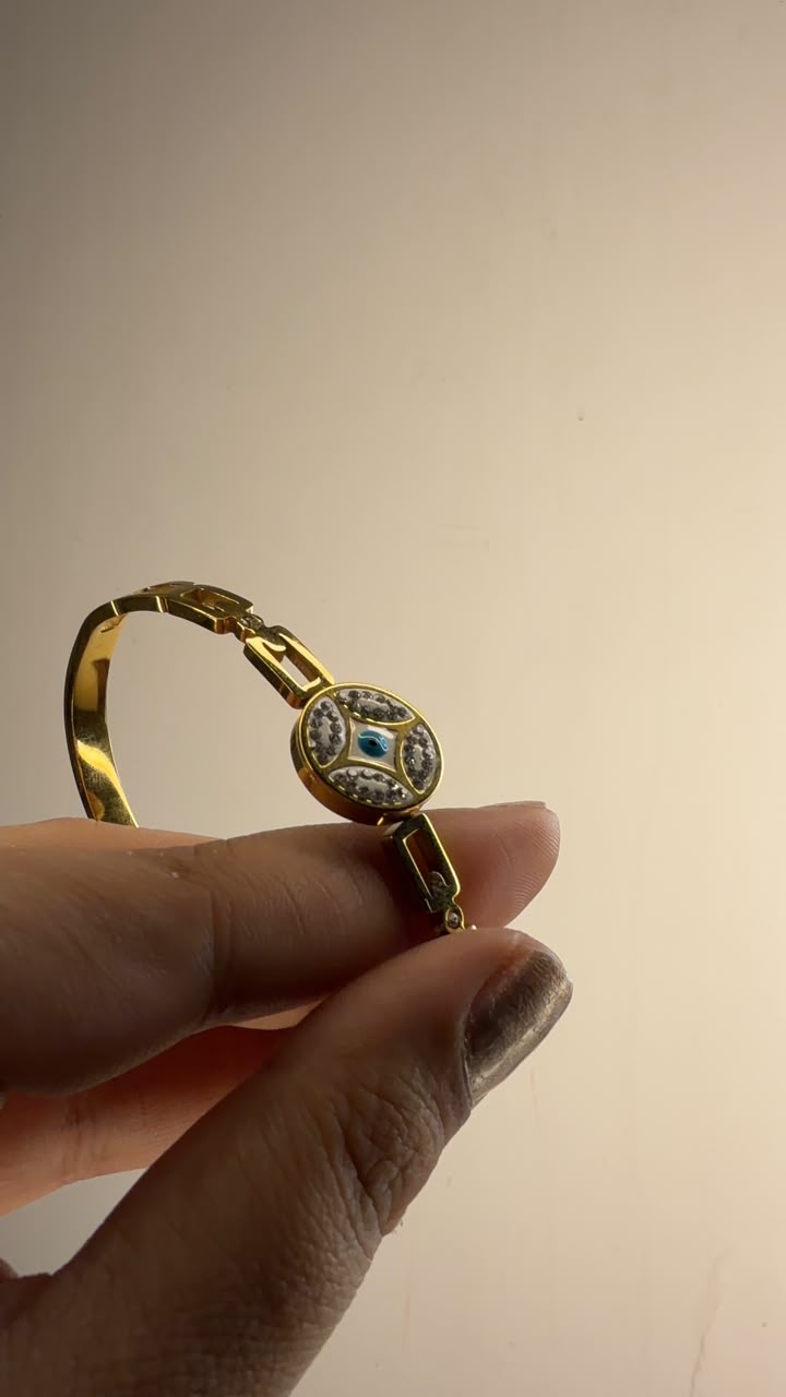 Gold tone bangle with round crystal evil eye motif