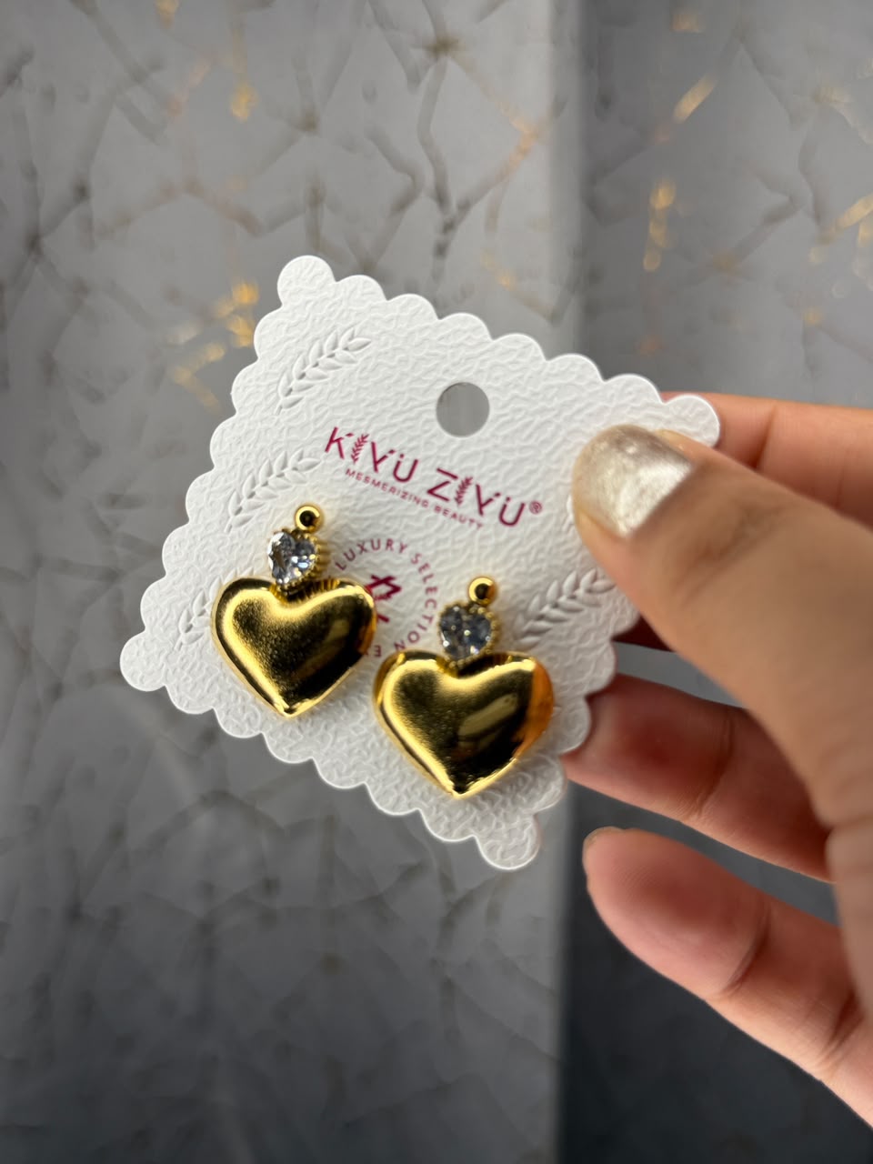 Gold tone heart stud earrings with clear crystal accents