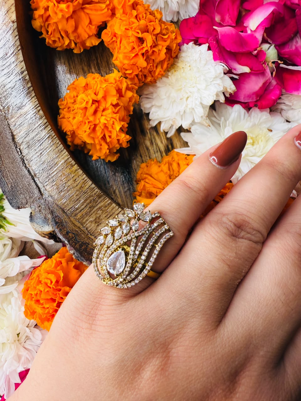 Gold tone crystal swirl statement ring with teardrop center stone