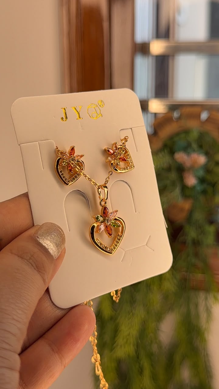 Gold tone floral heart pendant and matching earrings set with multicolor crystals