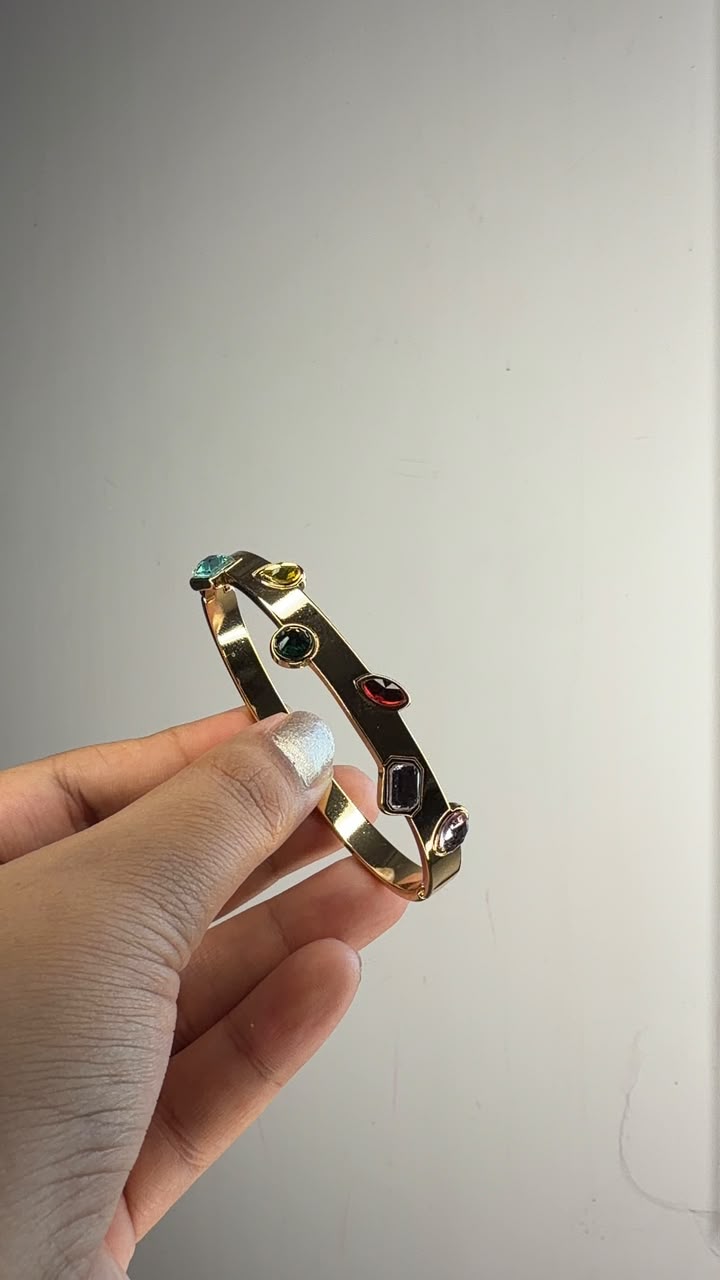 Gold tone bangle pair with multicolor gemstone accents
