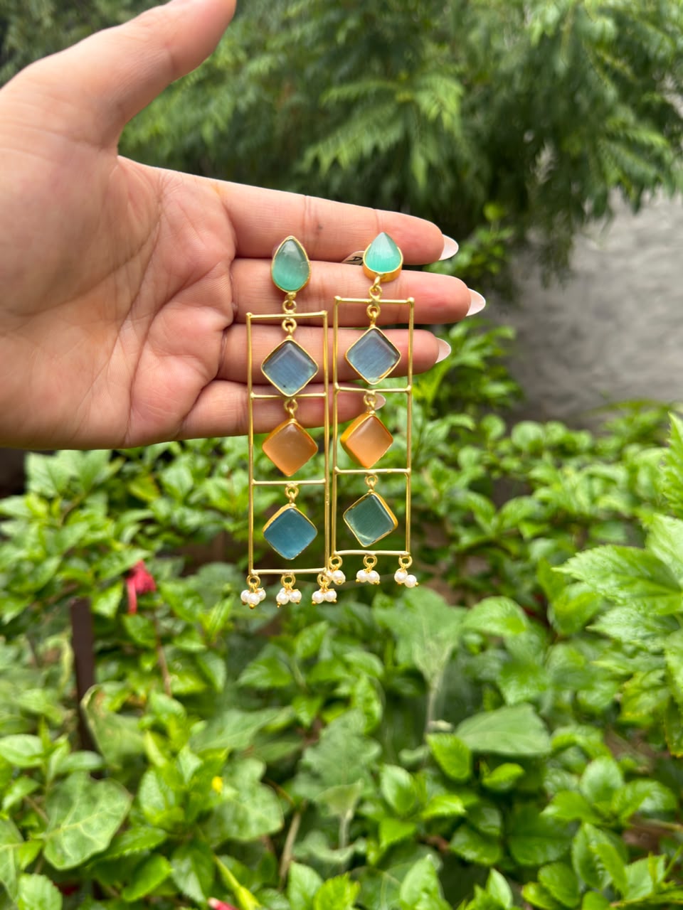 Long geometric gold tone earrings with pastel blue green and peach stones