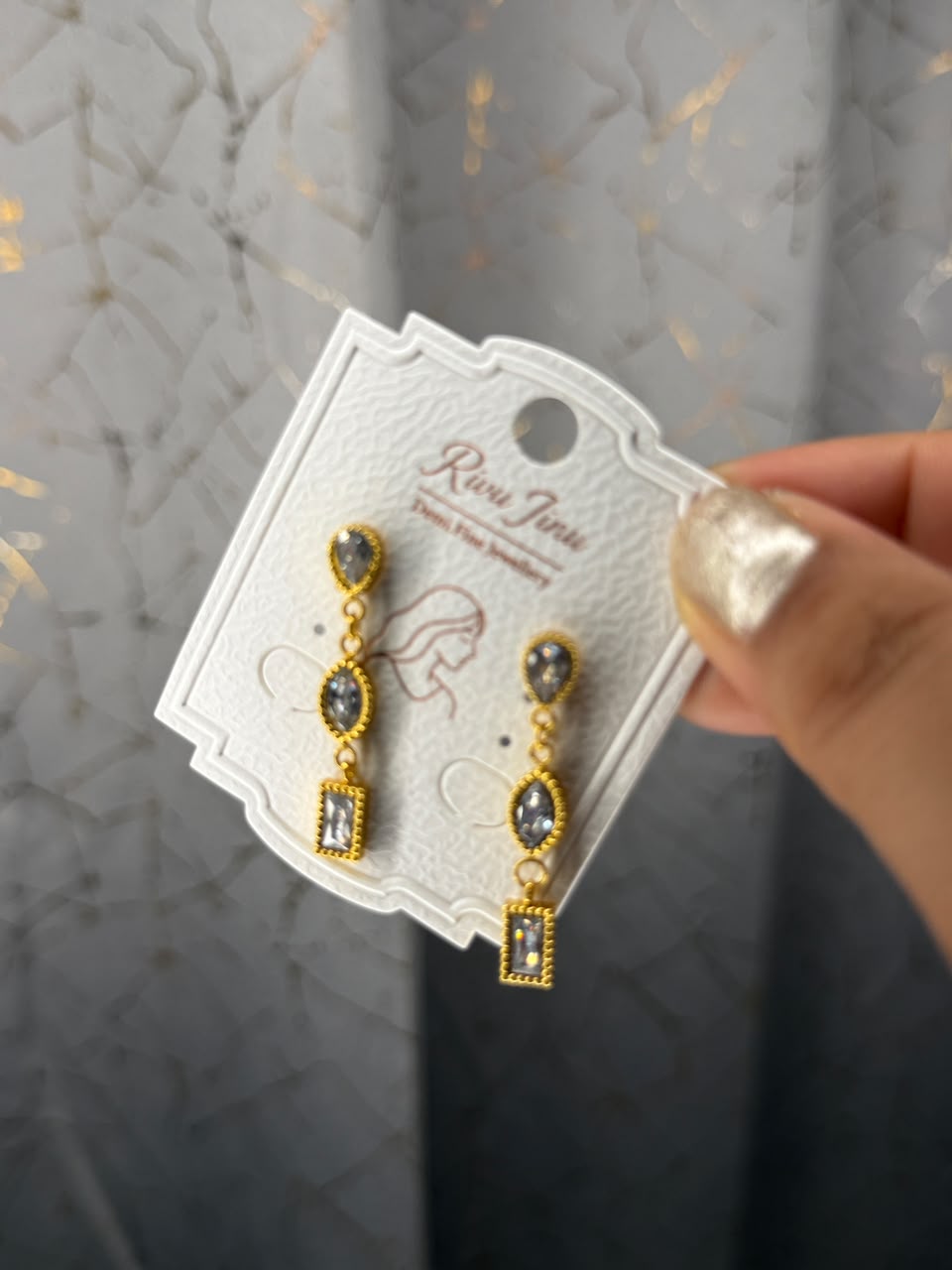 Gold tone linear drop earrings with smoky crystal stones
